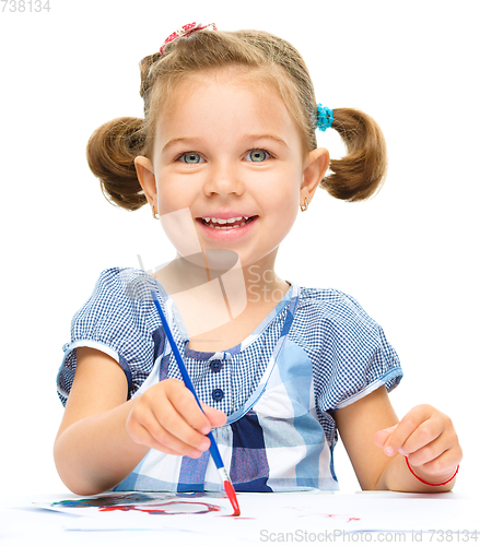 Image of Little girl is painting with gouache