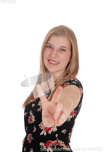 Image of Woman making victory sign and smiling