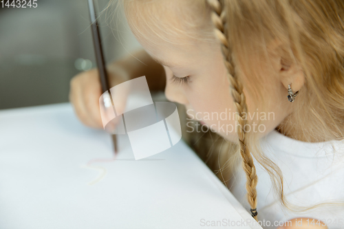 Image of Little girl studying to write or draw. Homeschooling concept