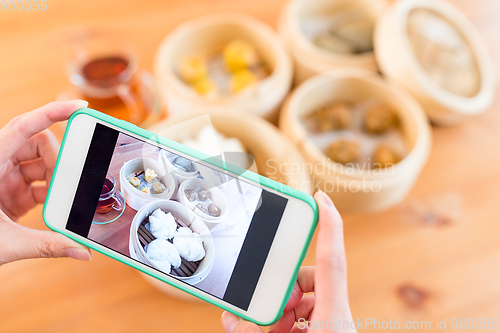 Image of Woman taking photo on chinese dim sum