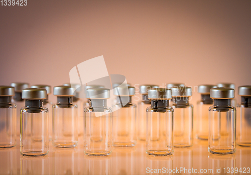 Image of Vaccine glass bottles on orange background
