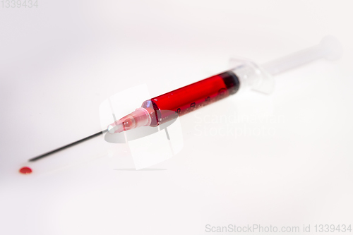 Image of Syringe with blood on white background