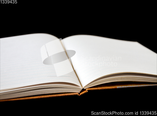 Image of Open blank notebook on black background