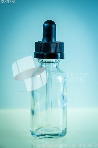 Image of Glass dropper bottle on blue background
