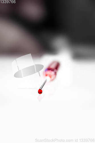 Image of Syringe needle with blood macro view