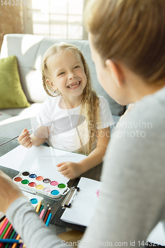 Image of Teacher and little girl, or mom and daughter. Homeschooling concept