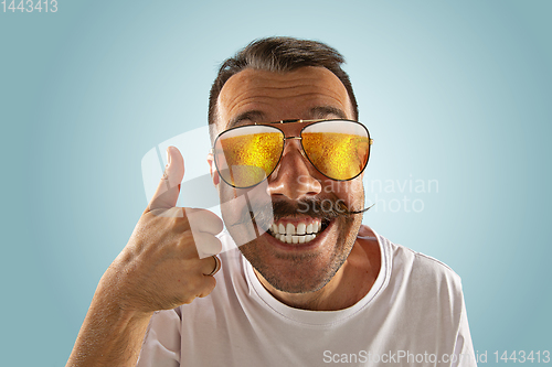 Image of Oktoberfest man with sunglasses full of light beer