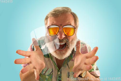 Image of Oktoberfest senior man with sunglasses full of light beer