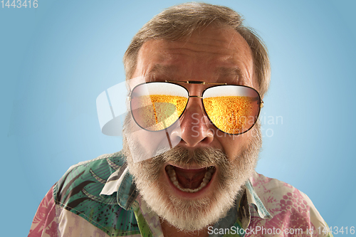 Image of Oktoberfest senior man with sunglasses full of light beer