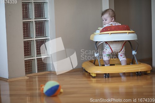 Image of baby learning to walk in walker