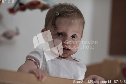 Image of cute little one year old baby and making first steps in bed