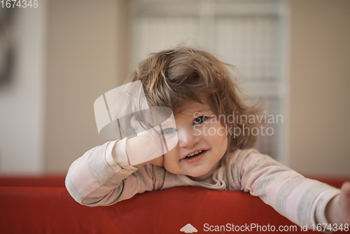 Image of little baby girl with strange hairstyle and curlers