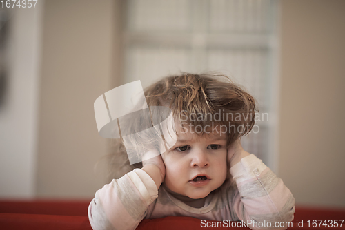 Image of little baby girl with strange hairstyle and curlers