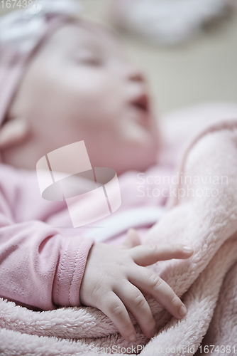 Image of newborn baby sleeping at home in bed