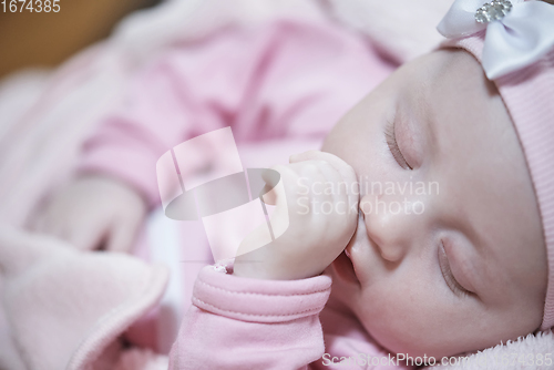 Image of newborn baby sleeping at home in bed