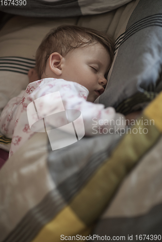 Image of newborn baby sleeping at home in bed