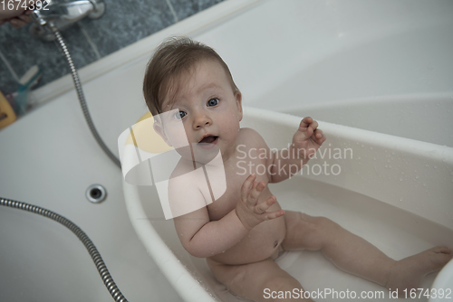 Image of cute little baby girl taking a bath