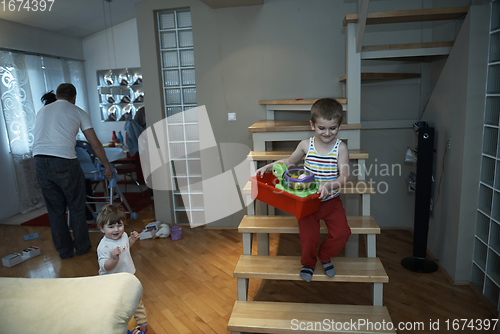 Image of Little child playing and bring toys to sister