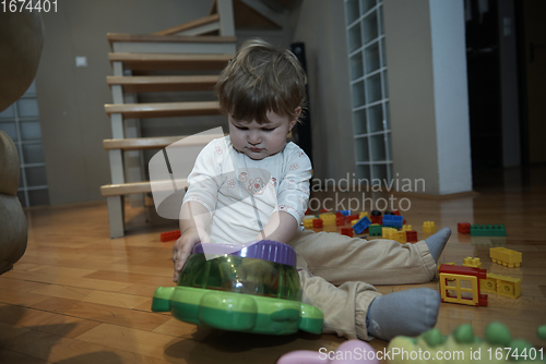 Image of Adorable cute beautiful little baby girl playing with toys at home