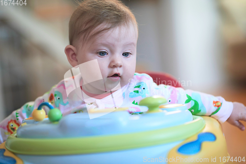 Image of baby learning to walk in walker