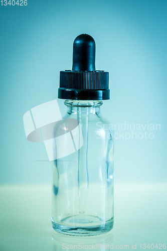 Image of Glass dropper bottle on blue background