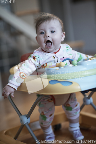 Image of baby learning to walk in walker