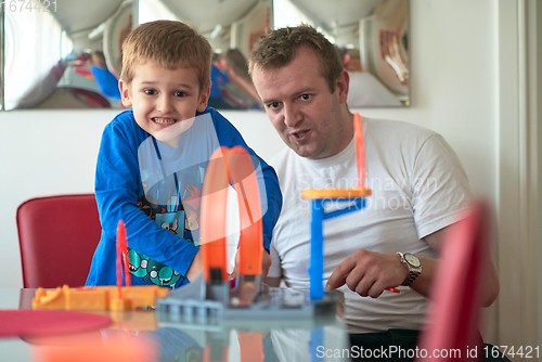 Image of Father and children playing car toy game