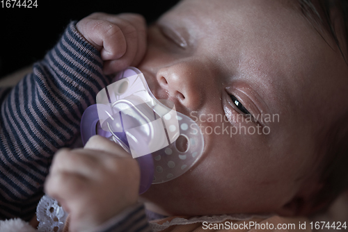 Image of One month newborn baby sleeping in bed