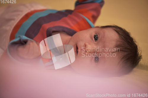 Image of One month newborn baby sleeping in bed