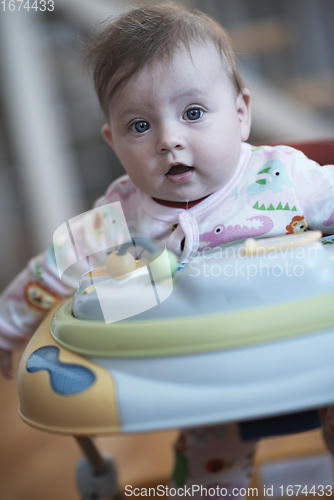 Image of baby learning to walk in walker