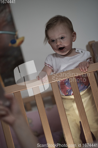 Image of cute little one year old baby and making first steps in bed