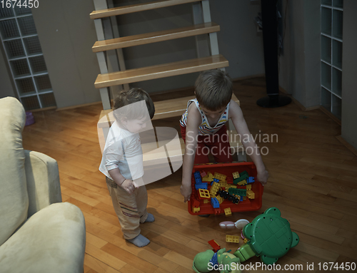 Image of Little child playing and bring toys to sister