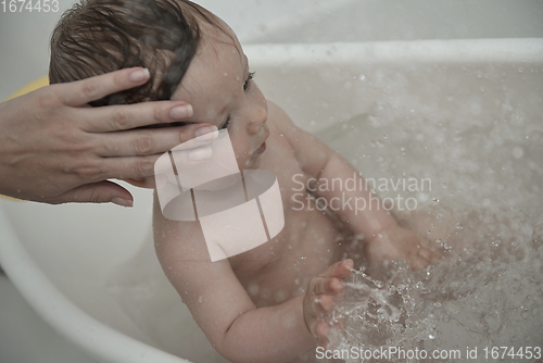 Image of cute little baby girl taking a bath