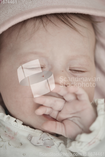 Image of newborn baby sleeping at home in bed