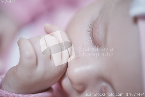 Image of newborn baby sleeping at home in bed