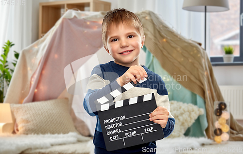 Image of happy little boy with clapperboard at home