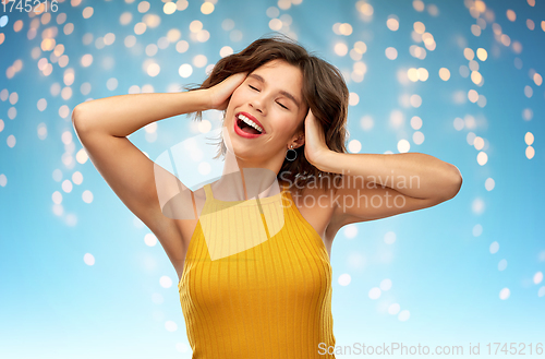 Image of happy laughing young woman in yellow top