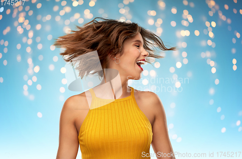 Image of happy young woman shaking head over lights