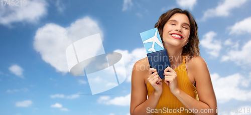 Image of happy young woman with air ticket and passport