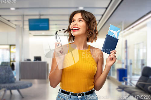 Image of happy young woman with air ticket at airport