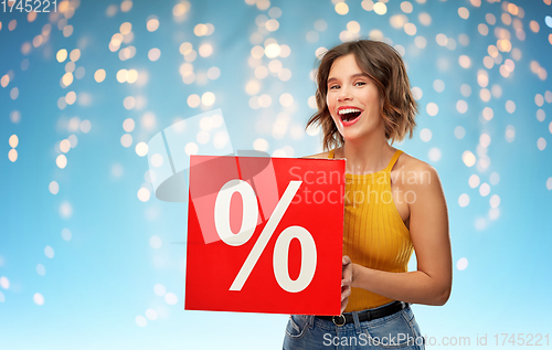 Image of smiling young woman with sale sign over lights