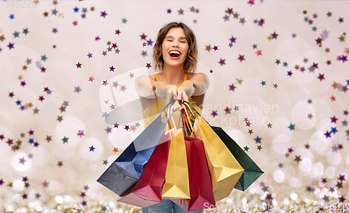 Image of happy smiling young woman with shopping bags