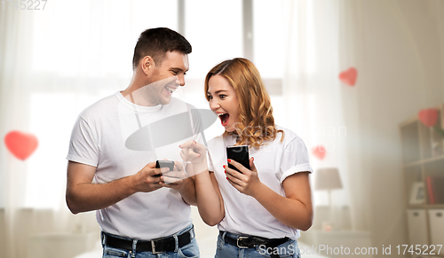 Image of happy couple in white t-shirts with smartphones