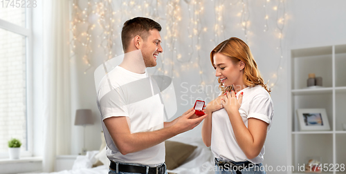 Image of man giving woman engagement ring on valentines day