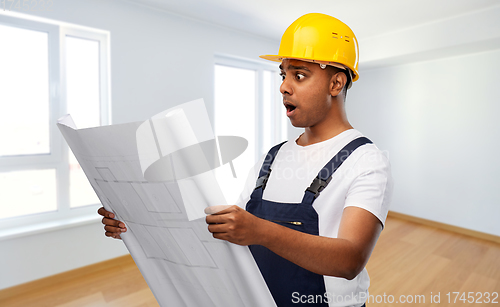 Image of shocked indian builder in helmet with blueprint