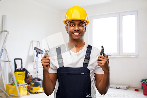 Image of indian builder in helmet with wrench and pliers