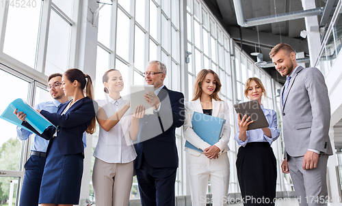 Image of business team with tablet pc and folders at office