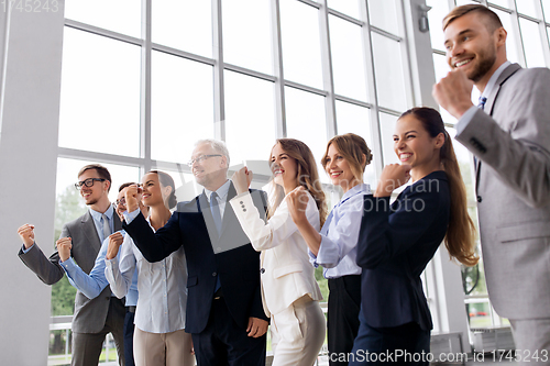 Image of happy business team celebrating success at office