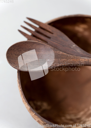 Image of close up of coconut bowl, wooden spoon and fork