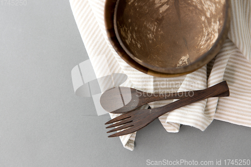 Image of close up of coconut bowl, wooden spoon and fork